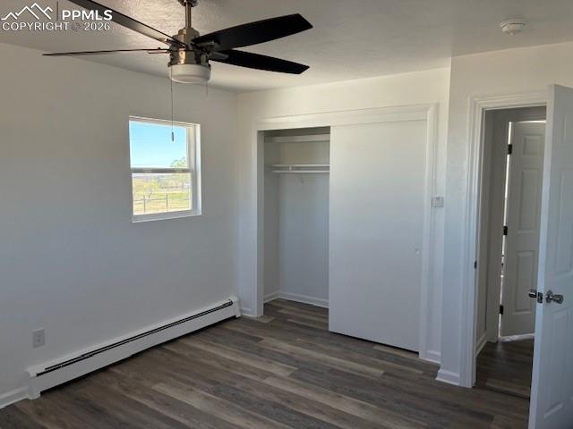 Image 20 of 36: Unfurnished bedroom featuring a baseboard radiator, dark wood finished floo