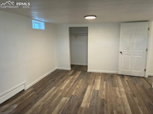 Image 22 of 36: Unfurnished bedroom featuring a closet, dark wood-type flooring, and basebo