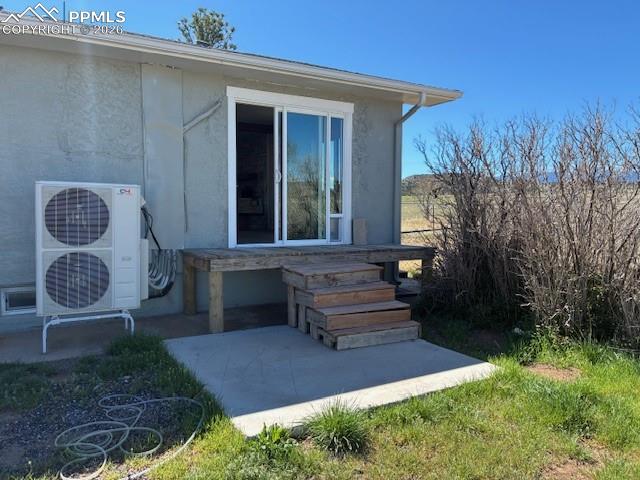 Image 27 of 36: View of exterior entry with stucco siding and a patio area