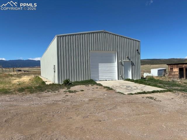 Image 30 of 36: View of outdoor structure featuring dirt driveway, a mountain view, and a v