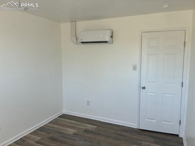 Image 8 of 36: Spare room with dark wood finished floors and a mini split for heating / co