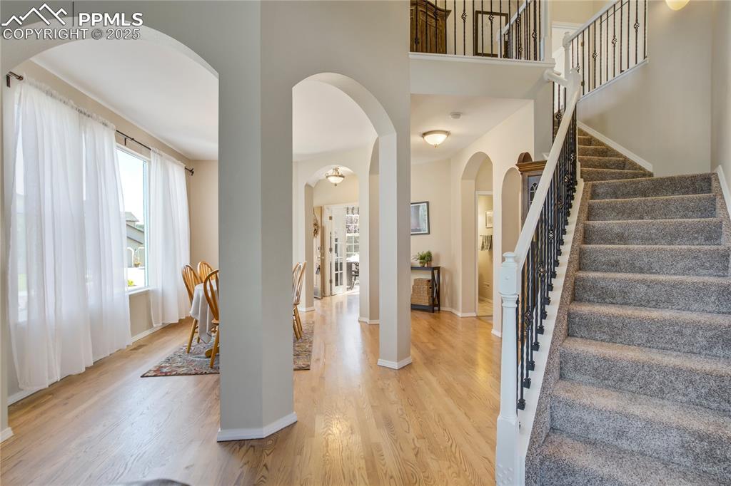 Image 17 of 43: Entrance foyer featuring arched walkways, light wood-style floors, stairs,