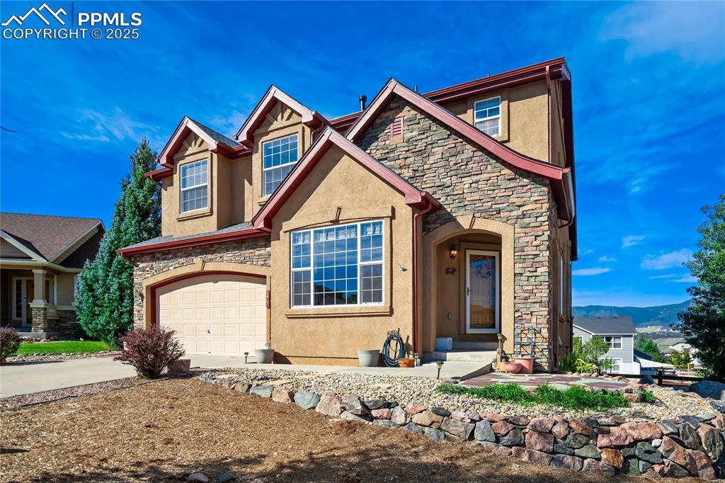 Image 2 of 43: Craftsman-style home featuring stone siding, stucco siding, an attached gar