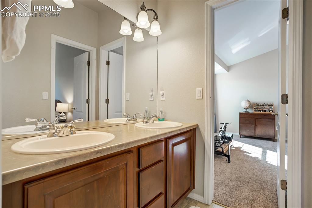Image 25 of 43: Full bathroom featuring connected bathroom, double vanity, and a chandelier
