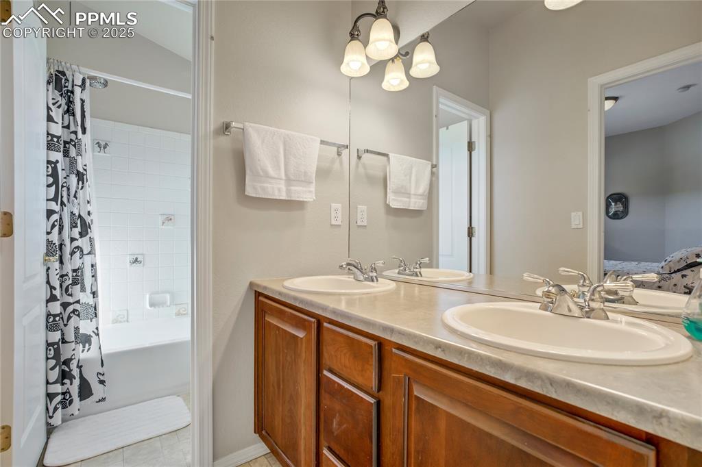 Image 26 of 43: Ensuite bathroom featuring shower / tub combo with curtain, light tile patt