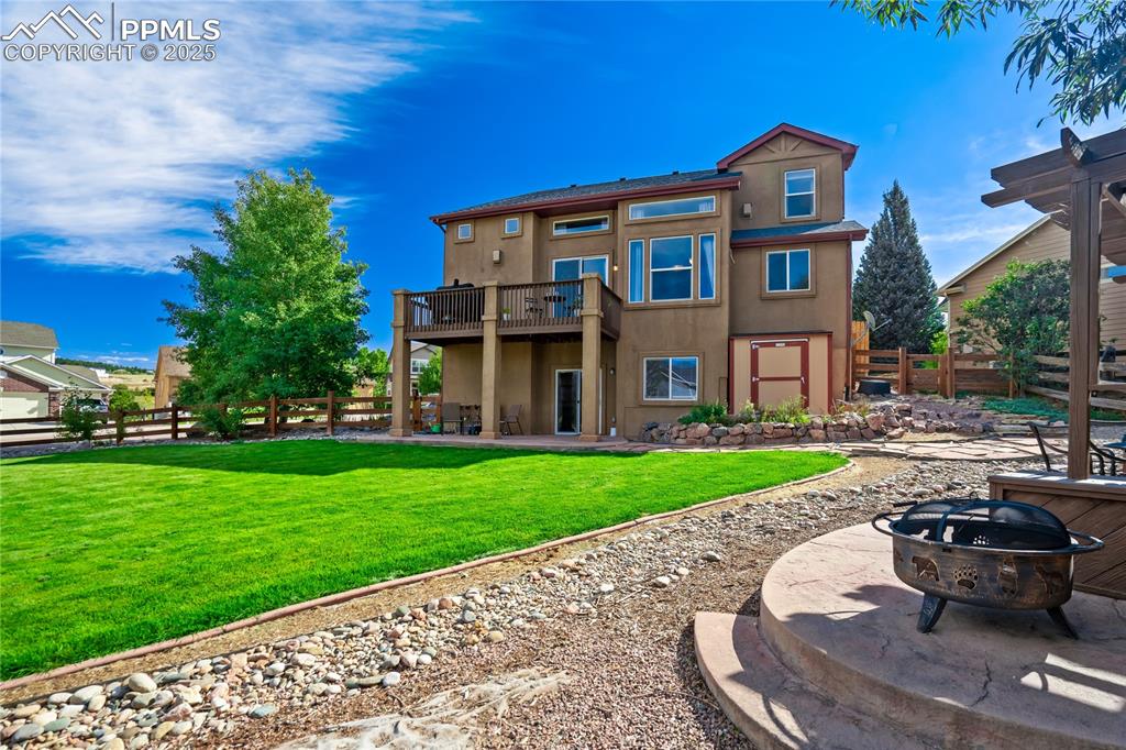 Image 37 of 43: Rear view of house featuring a patio area, a fenced backyard, and stucco si