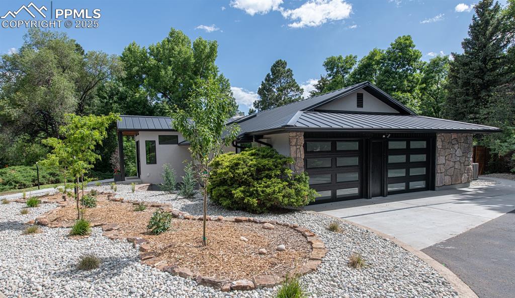 Image 3 of 50: Beautiful landscaping and new garage doors