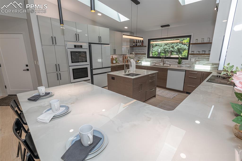 Image 9 of 50: Large counter bar and double ovens