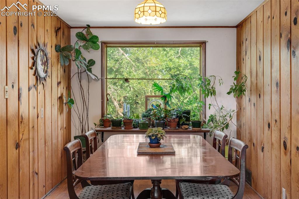 Image 11 of 50: Dining space featuring wooden walls and ornamental molding