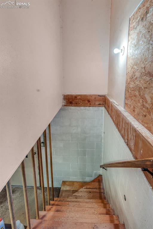 Image 16 of 50: Back stairs from kitchen to storage, utility and laundry areas.