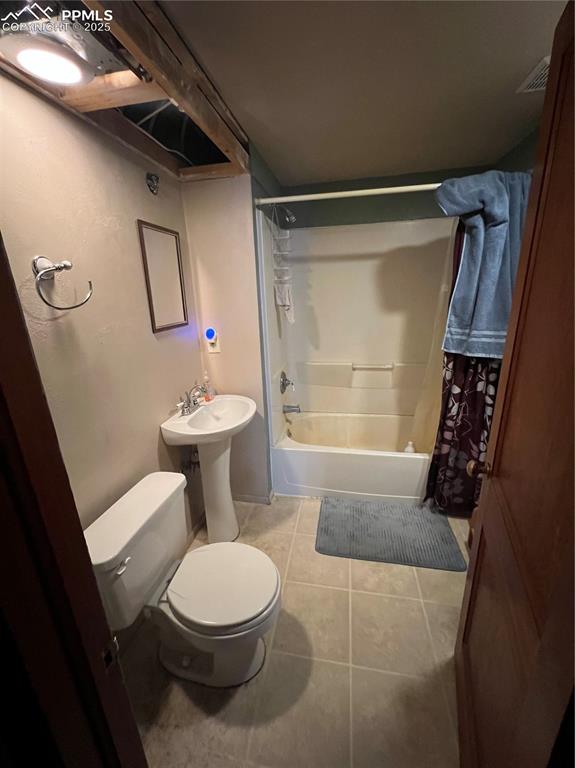 Image 35 of 50: Full bathroom with shower / bath combination with curtain and tile patterne