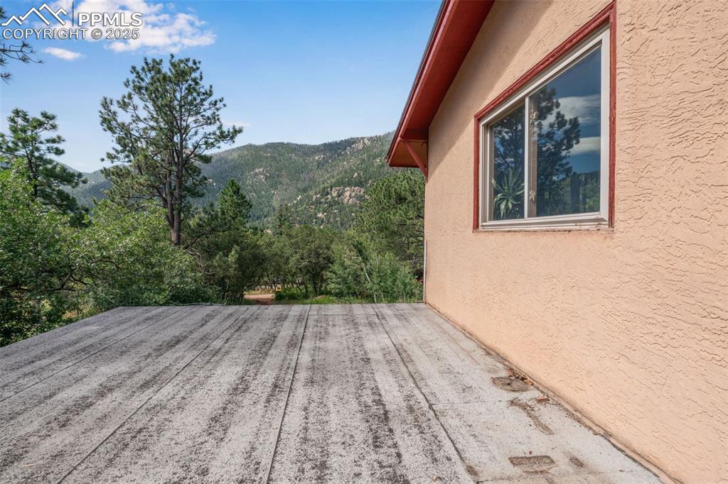 Image 37 of 50: Patio off of main level living room with a mountain view