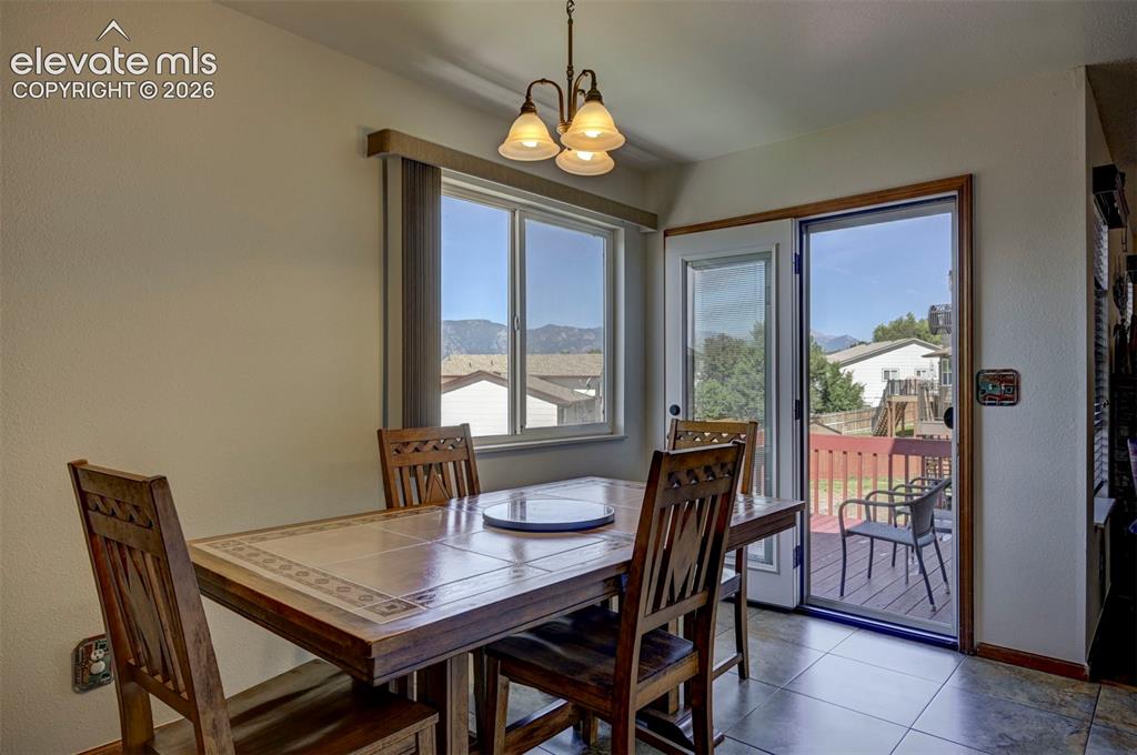 Image 13 of 50: Dining area in the kitchen leading to the wood deck with mountain views.