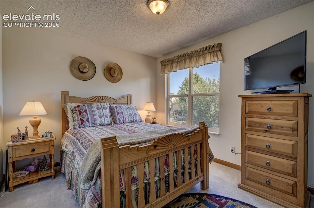 Image 29 of 50: Bedroom on upper level with window overlooking the front yard. Natural ligh
