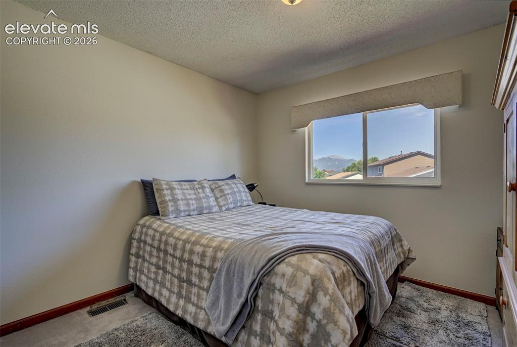 Image 31 of 50: Bedroom on the upper level with beautiful mountain views.
