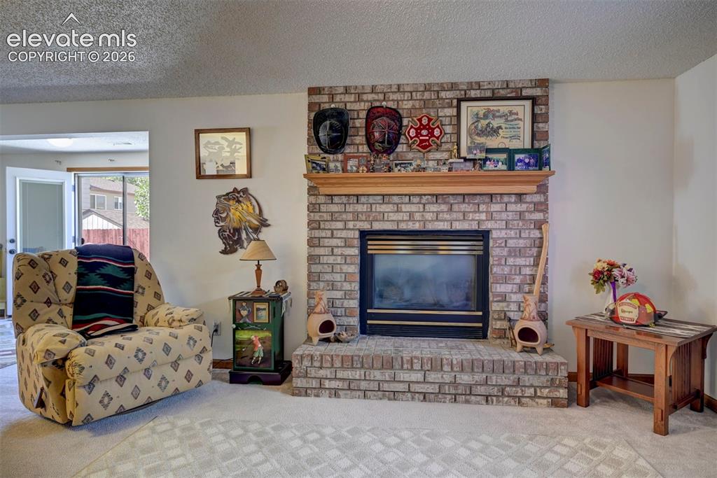 Image 39 of 50: Family Room in the finished basement with a second fireplace with brick sur