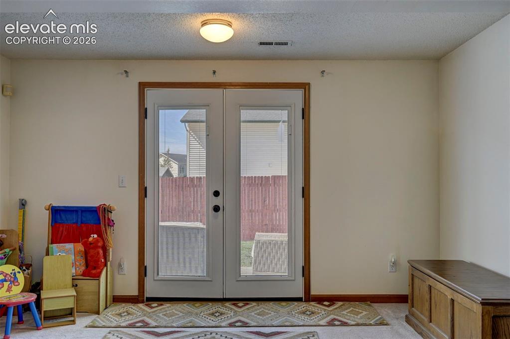 Image 43 of 50: French doors leading to the backyard in the finished basement.