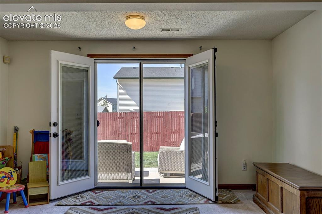 Image 44 of 50: French Door open to the patio and backyard.