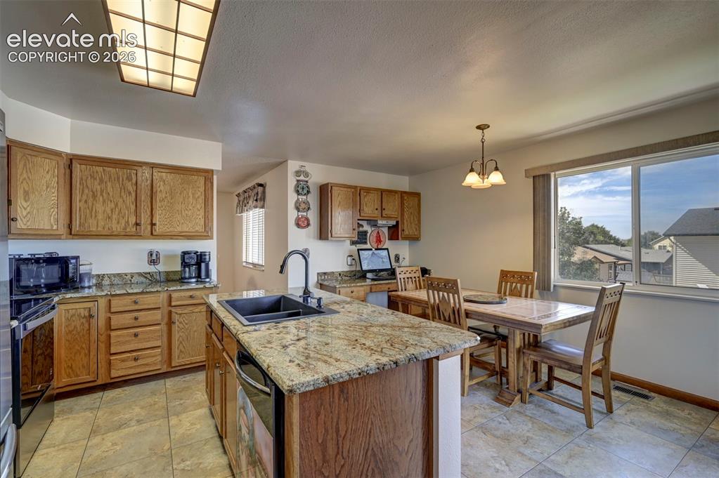 Image 9 of 50: Natural lighting in the kitchen with tile flooring.