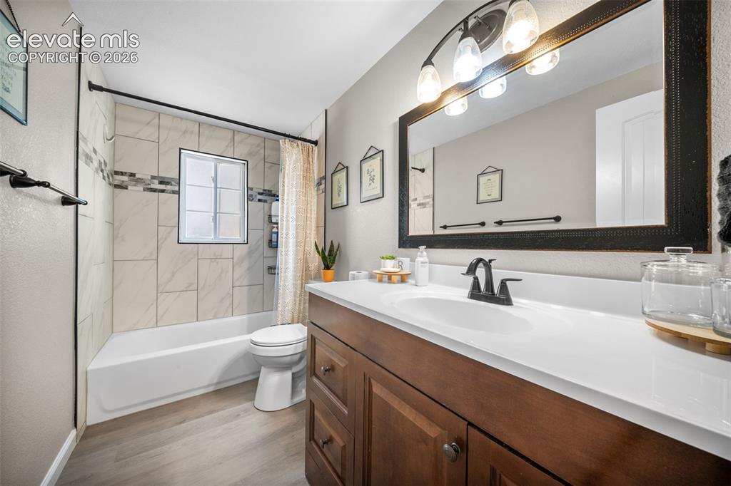 Image 18 of 39: Bathroom featuring a white bathtub and shower with tiled surround, a window