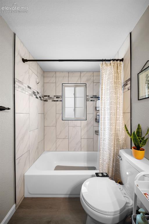 Image 19 of 39: Bathroom featuring a white bathtub, ceramic tile surround with decorative a