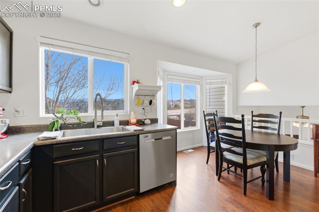 Image 13 of 44: Kitchen with dishwasher, dark wood finished floors, and pendant lighting