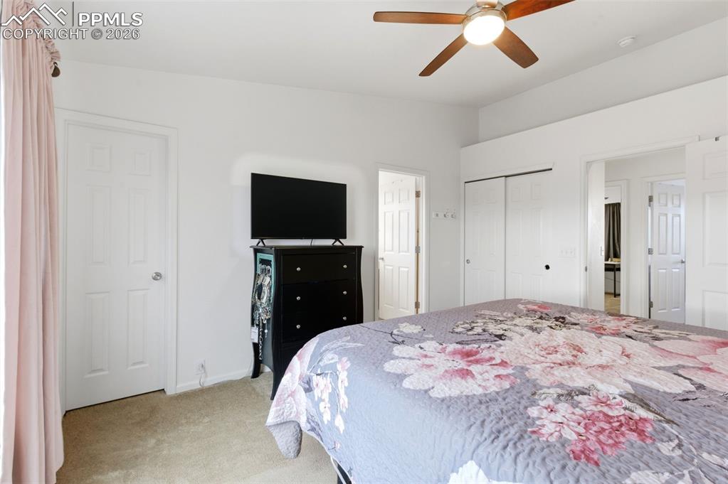 Image 23 of 44: Bedroom with light carpet, ceiling fan, and a closet
