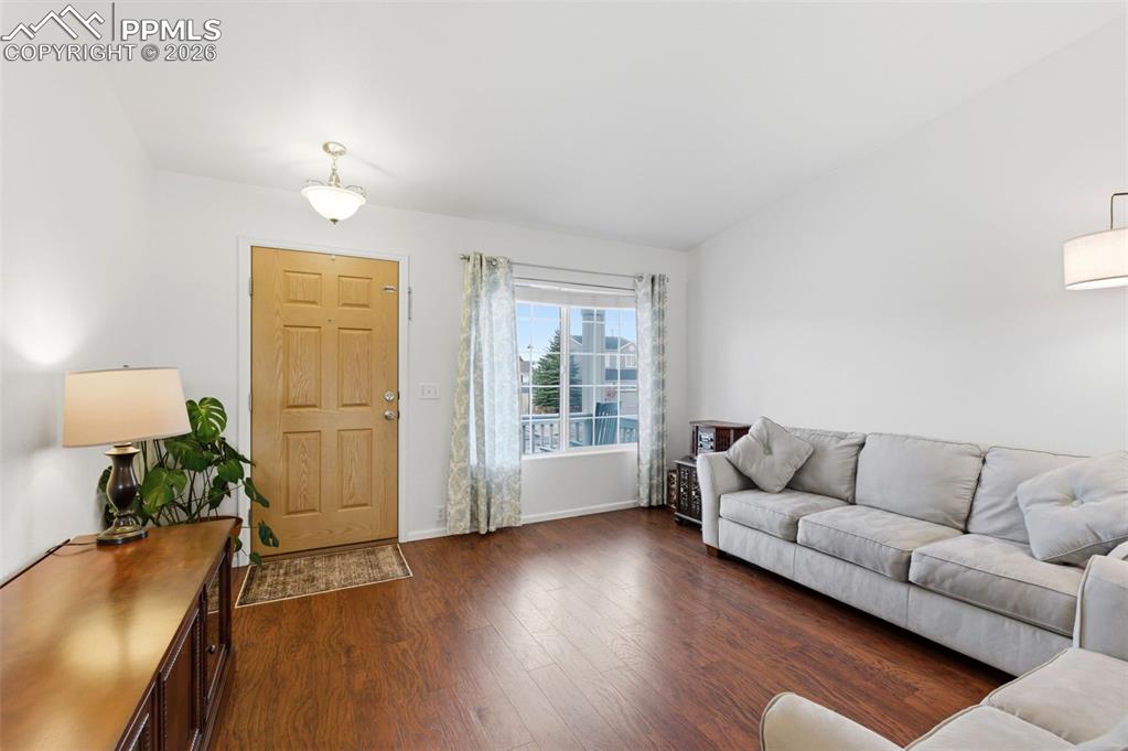 Image 7 of 44: Living room with dark wood-type flooring and lofted ceiling