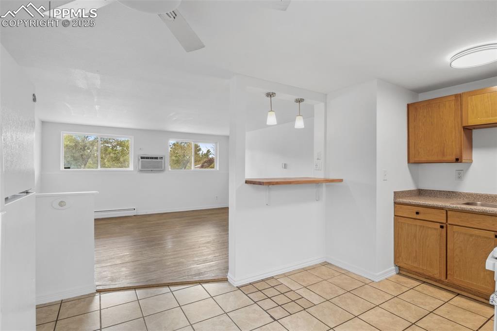 Image 5 of 17: Kitchen with light tile patterned floors, brown cabinets, light countertops