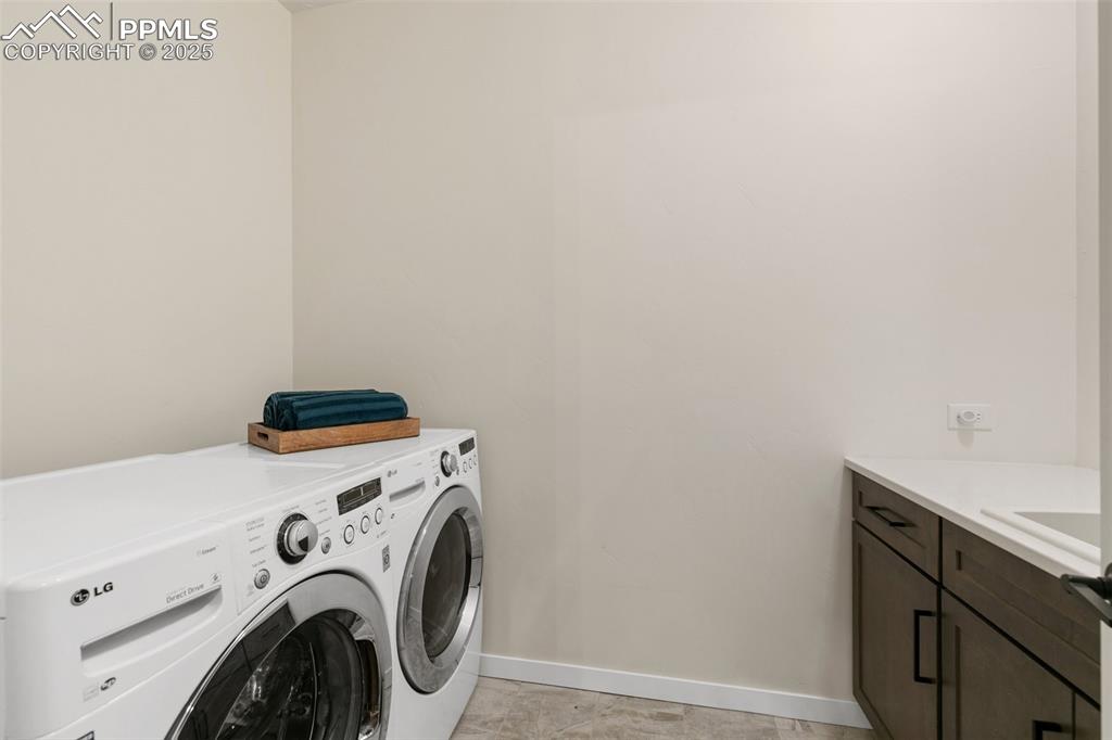 Image 32 of 49: Laundry area with built in cabinets & utility sink