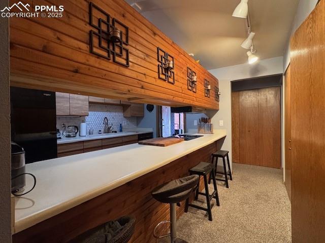 Image 13 of 17: Kitchen featuring a kitchen bar w bar top seating