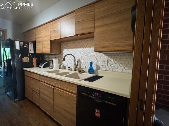 Image 14 of 17: light countertops, backsplash, black appliances, dark wood-style flooring,
