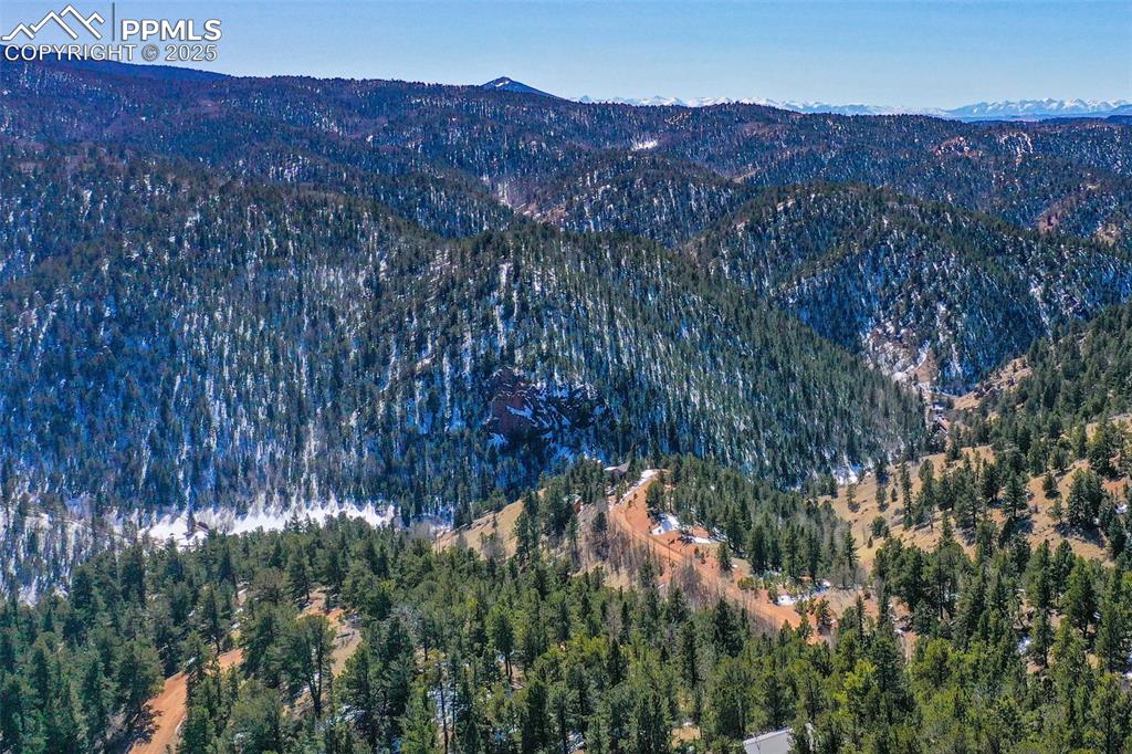 Image 16 of 19: Birds eye view of property with a mountain view and a wooded view