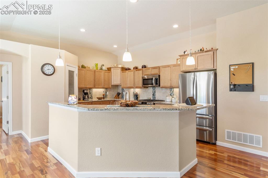 Image 10 of 33: Kitchen featuring appliances with stainless steel finishes, light wood fini