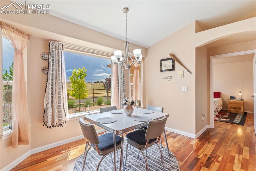 Image 14 of 33: Dining area with a chandelier, light wood-style flooring, arched walkways,