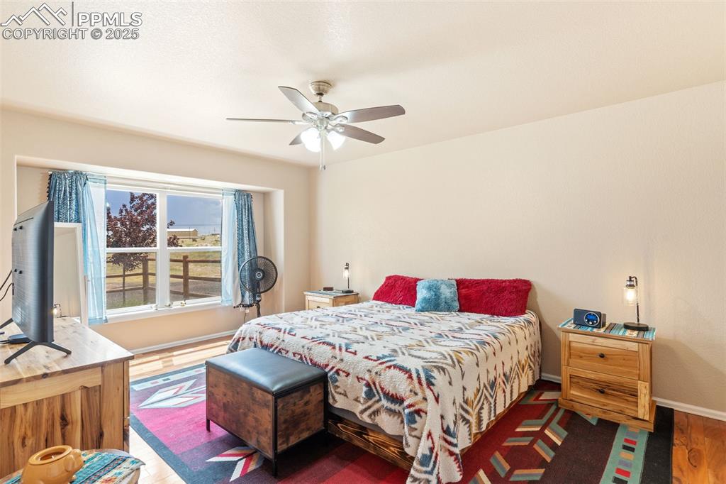 Image 15 of 33: Bedroom featuring wood finished floors and ceiling fan