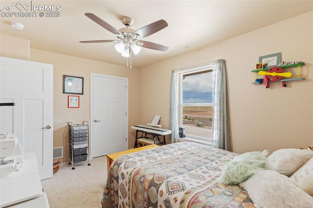 Image 20 of 33: Carpeted bedroom with a ceiling fan
