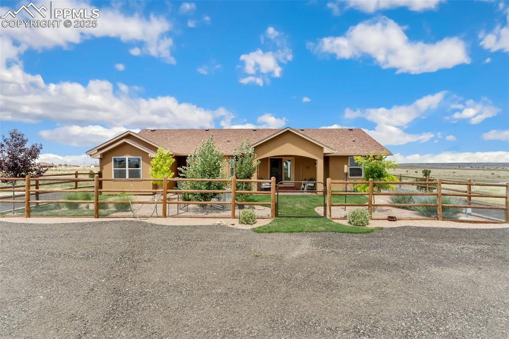Image 4 of 33: Ranch-style house with stucco siding and a gate