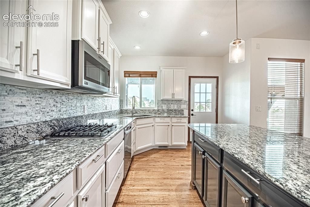 Image 17 of 48: Kitchen featuring white cabinetry with brushed nickel hardware, stainless s