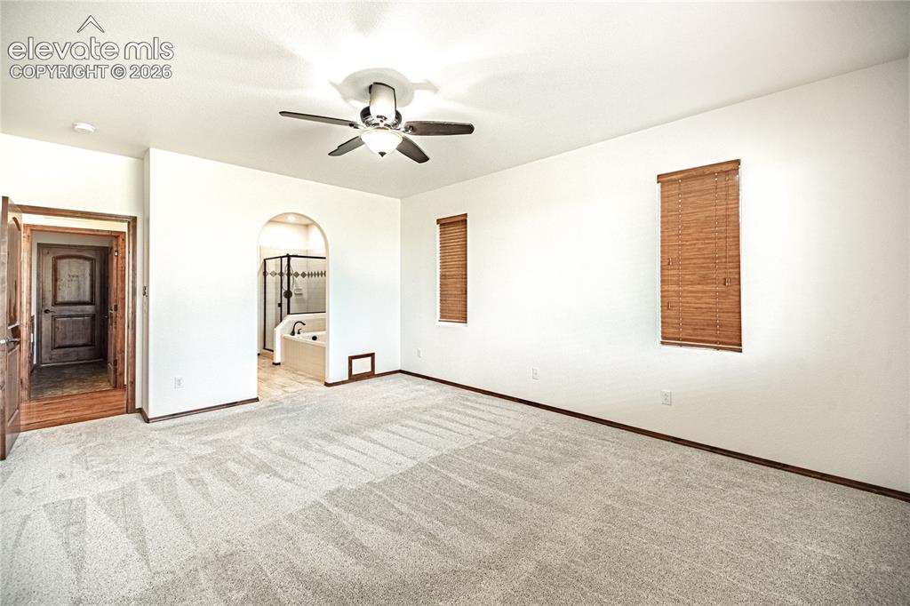 Image 19 of 38: Spacious room featuring light-toned carpeting and white walls