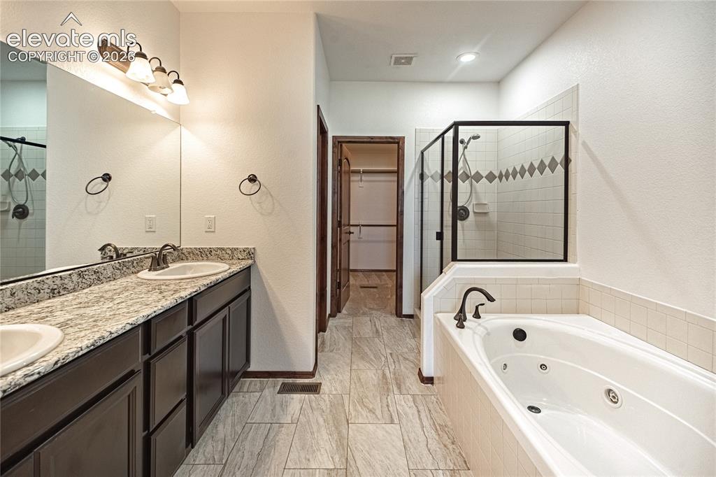 Image 22 of 38: Bathroom featuring a double vanity with granite countertop, individual sink