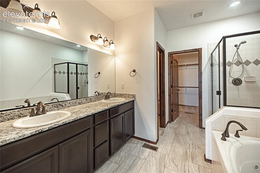 Image 23 of 38: Double vanity with granite countertop, individual sinks, and bronze-finish