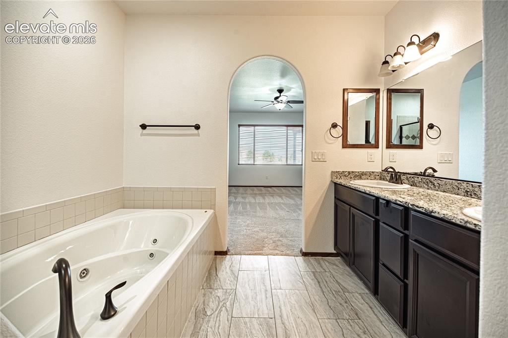 Image 25 of 38: Bathroom featuring a jetted soaking tub, dual vanity with undermount sinks,
