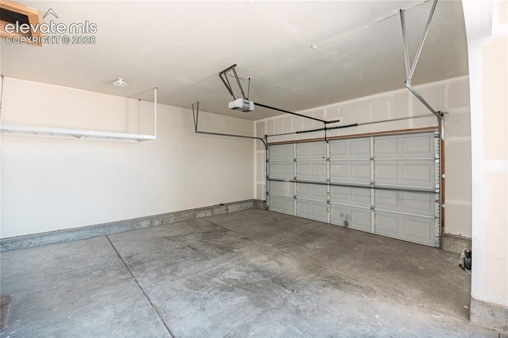 Image 40 of 48: Spacious garage featuring a concrete floor, painted walls, an overhead gara