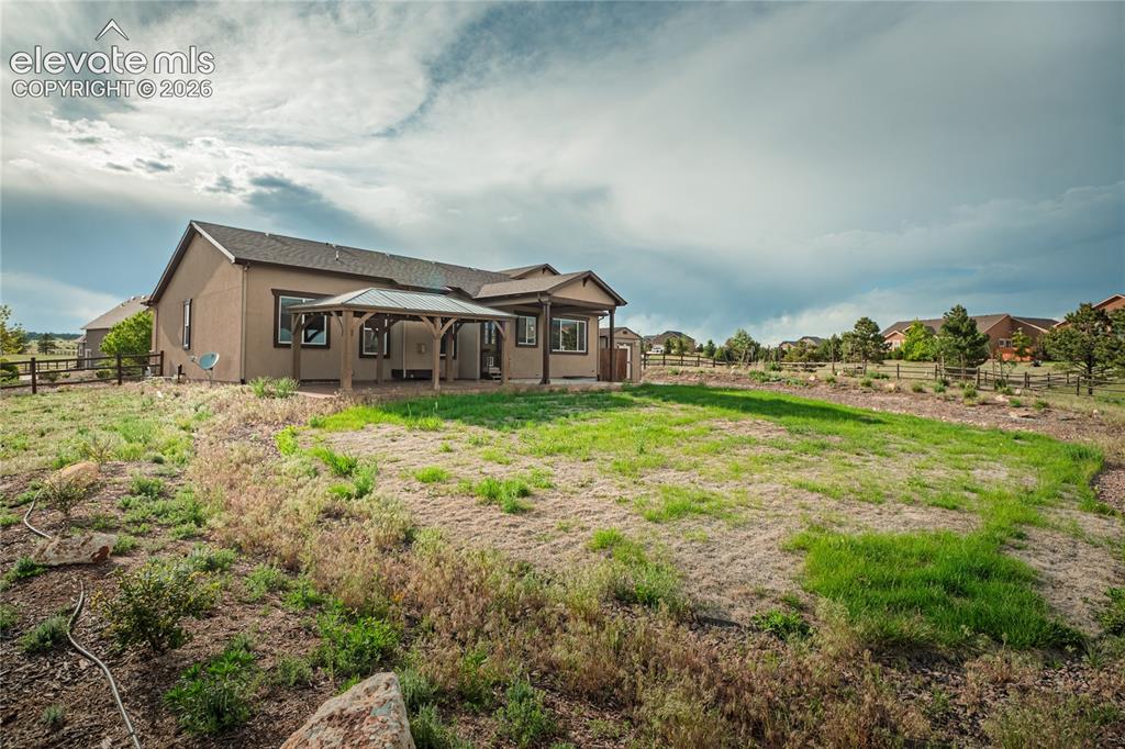 Image 43 of 48: Expansive backyard featuring a combination of natural landscaping and a par