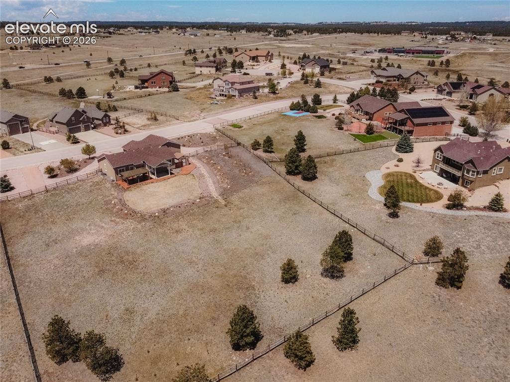 Image 48 of 48: Expansive residential property featuring a large open field, scattered pine