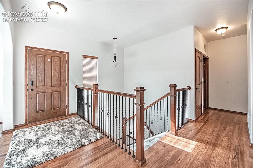 Image 5 of 38: Entry foyer featuring rich wood-finish flooring, a paneled solid wood entry