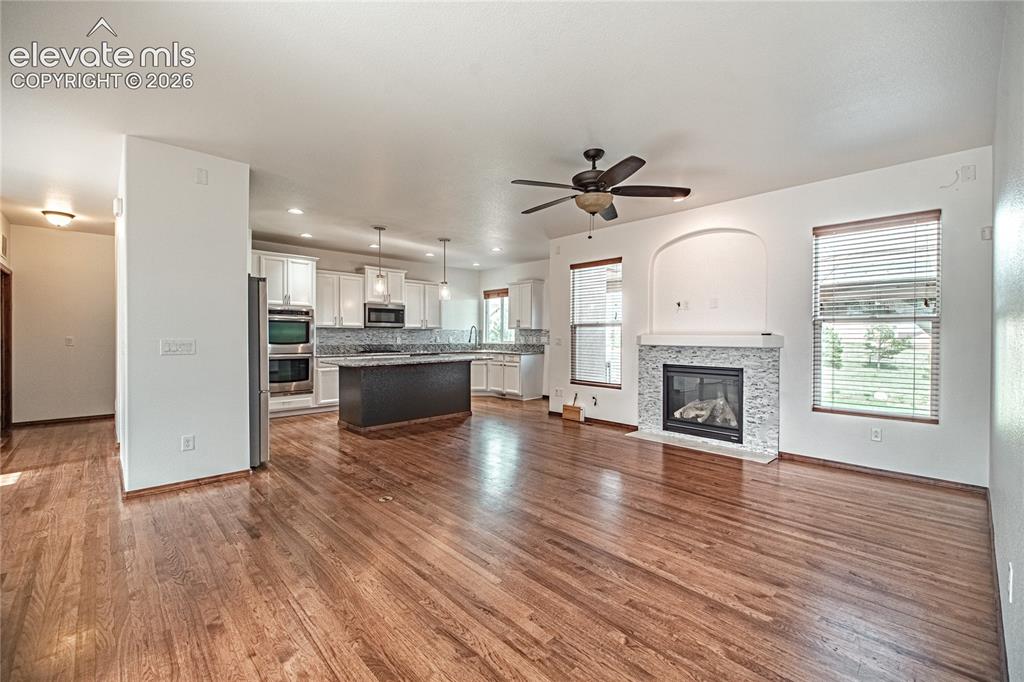 Image 9 of 38: Open-concept living area featuring rich wood-finish flooring
