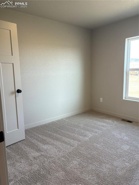 Image 14 of 16: Empty room featuring light carpet and a textured ceiling