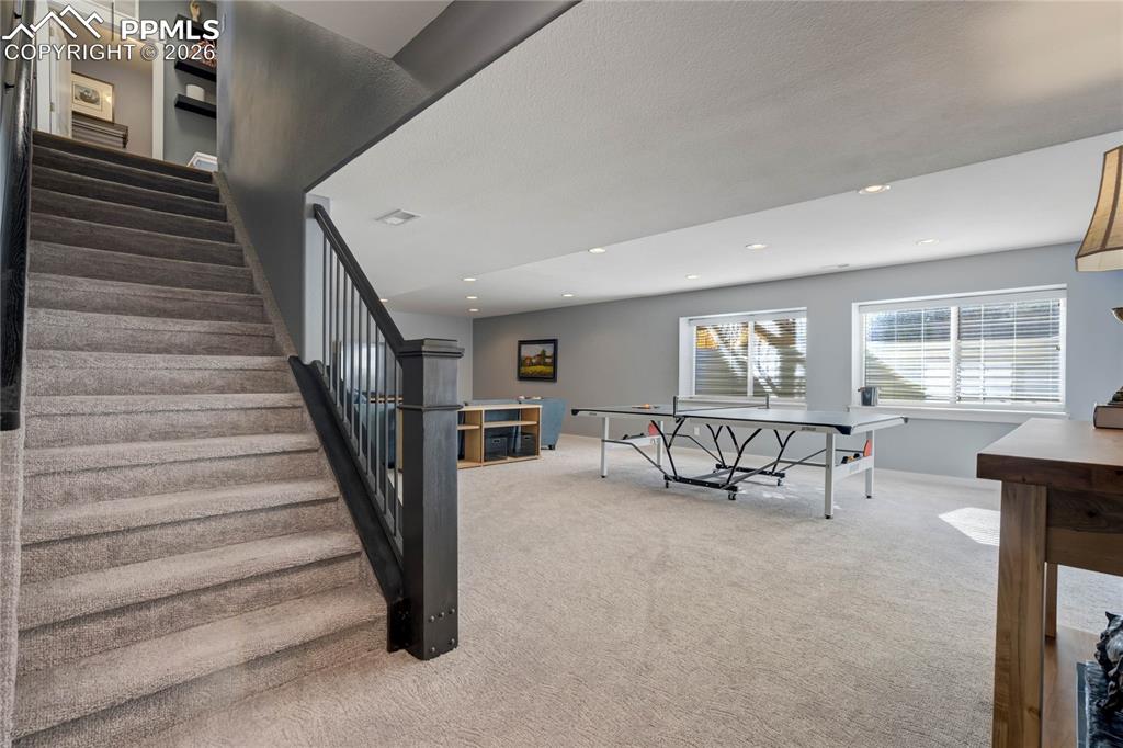 Image 36 of 50: Wide staircase leads down to the finished basement.
